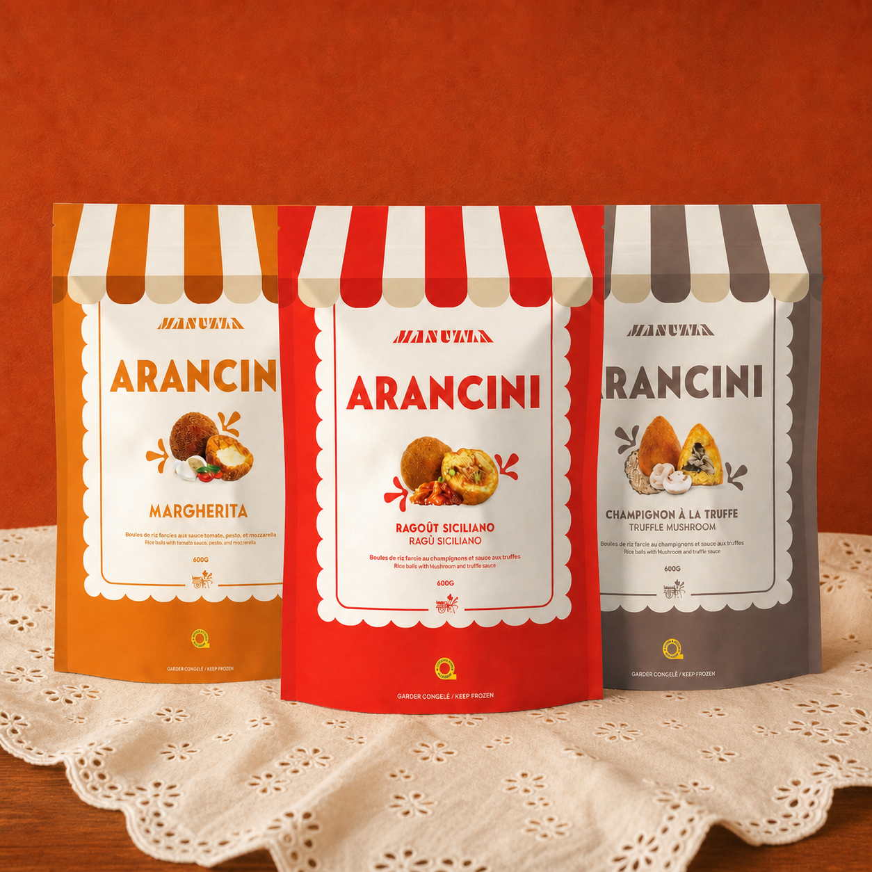 Three Manuzza frozen mini arancini flavours on an embroidered eyelet tablecloth